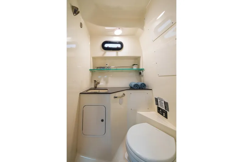 Slide: The Image of Manufacturer Provided Image: 2023 Boston Whaler 325 Conquest boat bathroom with sink, toilet, and storage. - 23