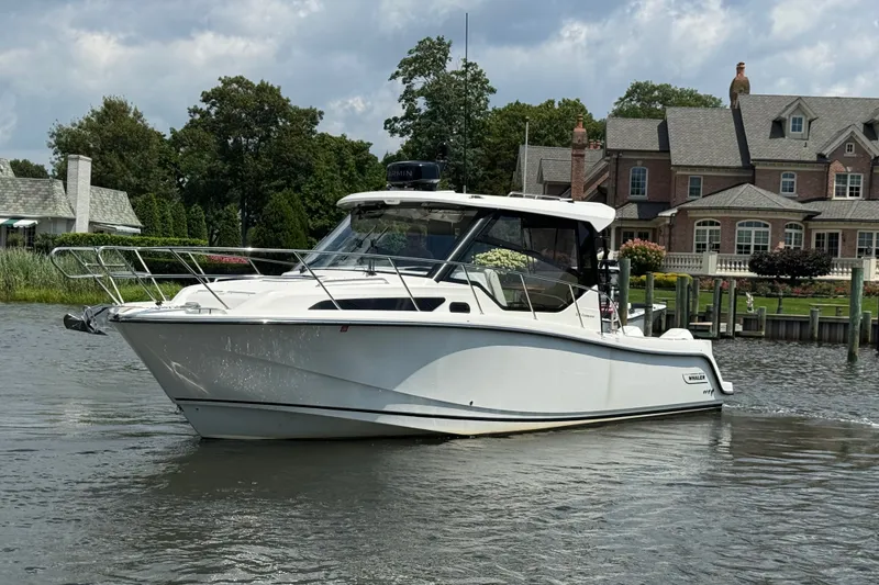 The Image of 2023 Boston Whaler 325 Conquest boat cruising near waterfront homes. - 0