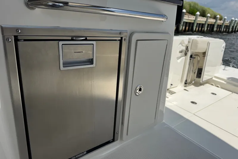 Slide: The Image of 2023 Boston Whaler 325 Conquest boat interior with Dometic fridge and storage compartments. - 14