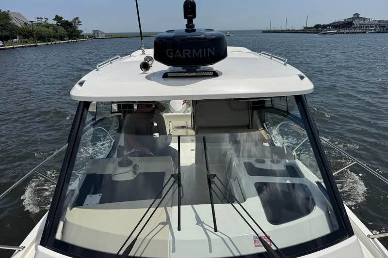 Slide: The Image of 2023 Boston Whaler 325 Conquest boat navigating on a sunny day with Garmin equipment. - 8