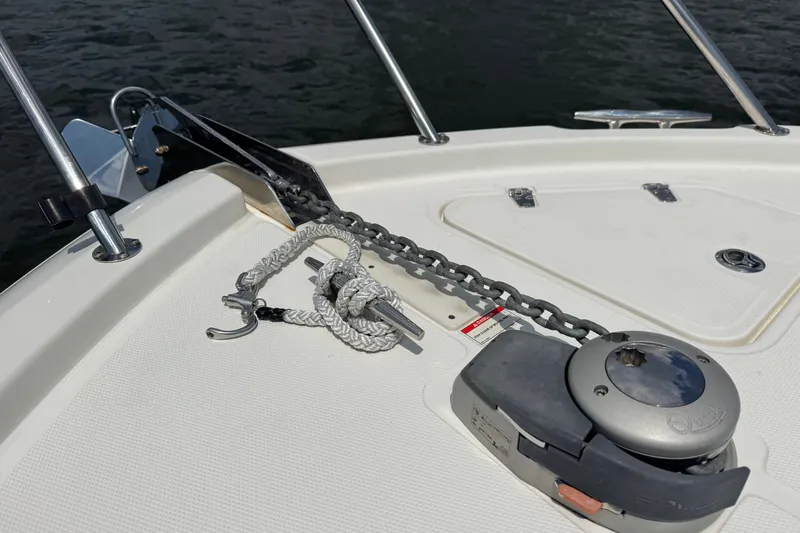 Slide: The Image of 2023 Boston Whaler 325 Conquest anchor system on deck, featuring chain and winch. - 10