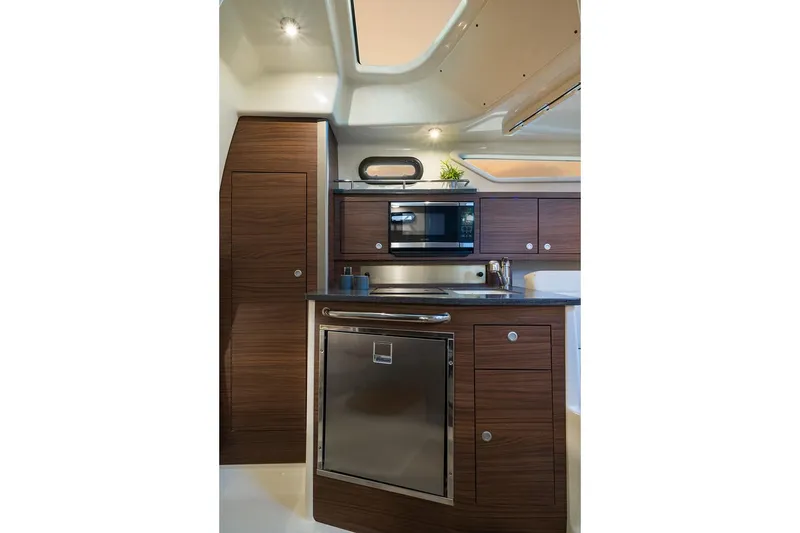 Slide: The Image of Manufacturer Provided Image: 2023 Boston Whaler 325 Conquest kitchen with modern appliances and wood cabinetry. - 21