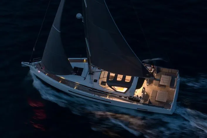 Slide: The Image of Manufacturer Provided Image: 2026 Jeanneau 55 sailing at night with illuminated deck and dark sails. - 3