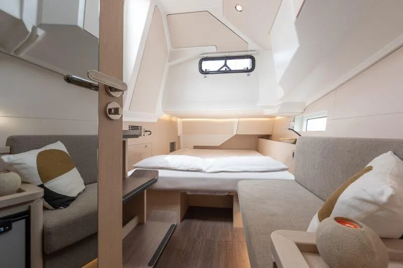 Slide: The Image of Manufacturer Provided Image: Luxurious interior of 2026 Jeanneau 55 yacht cabin with modern furnishings and cozy bedding. - 11