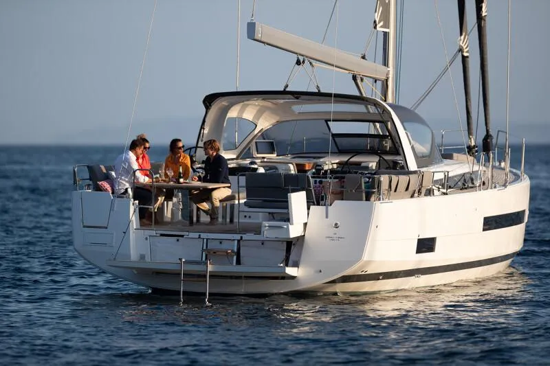 Slide: The Image of Manufacturer Provided Image: 2026 Jeanneau 55 yacht with people enjoying a meal on deck, sailing on calm waters. - 4