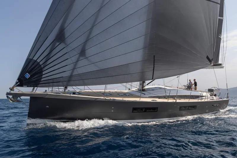 Slide: The Image of Manufacturer Provided Image: 2025 Jeanneau 60 yacht sailing on open water with sleek black sails. - 2