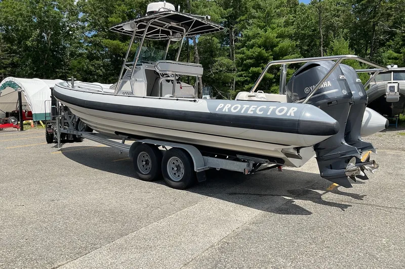 Slide: The Image of 2015 Protector 30 Center Console boat on trailer with Yamaha engines, parked outdoors. - 12