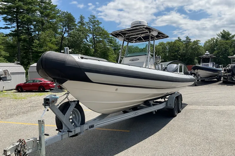 Slide: The Image of 2015 Protector 30 Center Console boat on trailer, parked outdoors under a cloudy sky. - 11