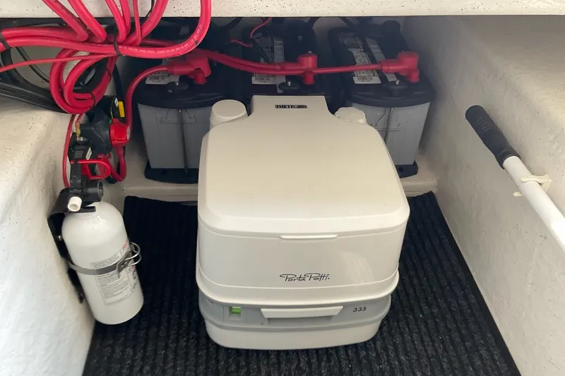 Slide: The Image of 2015 Protector 30 Center Console boat interior with Porta Potti, batteries, and fire extinguisher. - 19
