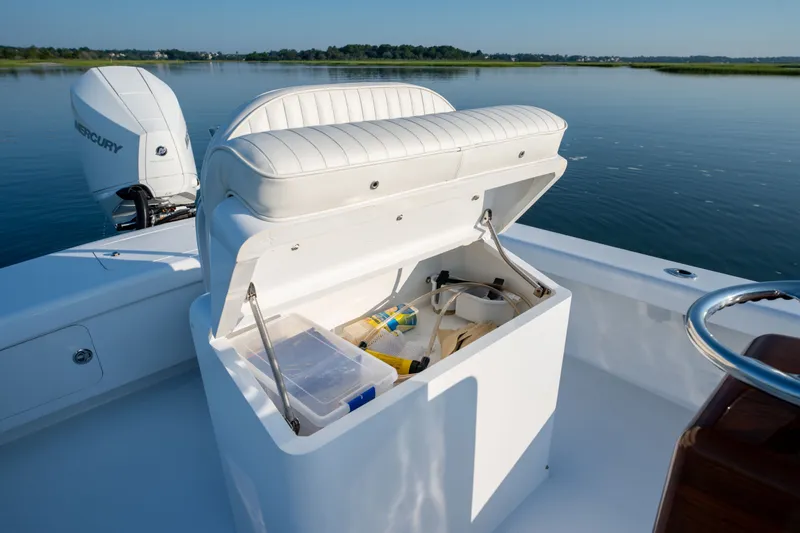 Slide: The Image of 2021 Harrison Boatworks 23 Center Console with open storage compartment on calm water. - 20