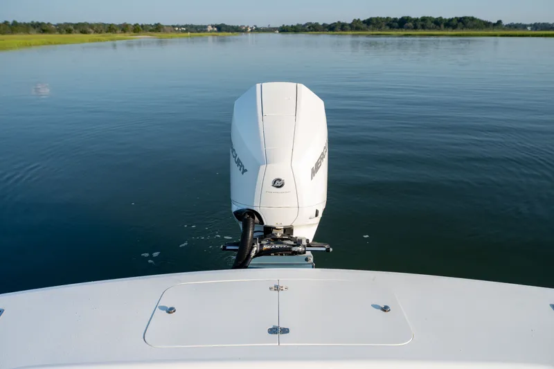 Slide: The Image of 2021 Harrison Boatworks 23 Center Console on calm water, rear view with outboard motor. - 23