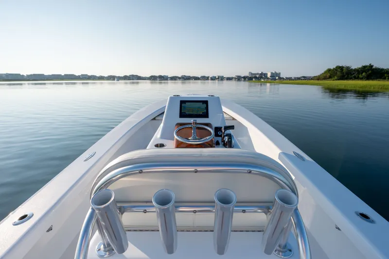 Slide: The Image of 2021 Harrison Boatworks 23 Center Console on calm water, showcasing sleek design and navigation console. - 14