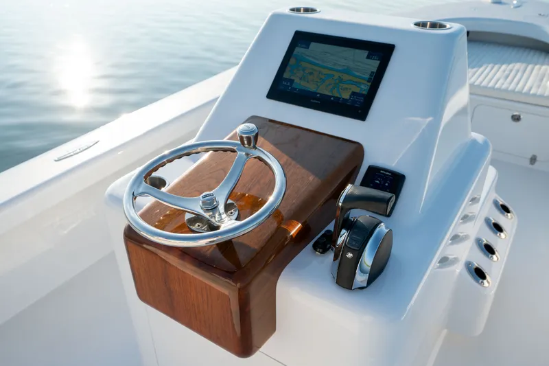 Slide: The Image of 2021 Harrison Boatworks 23 Center Console helm with steering wheel and navigation display. - 13