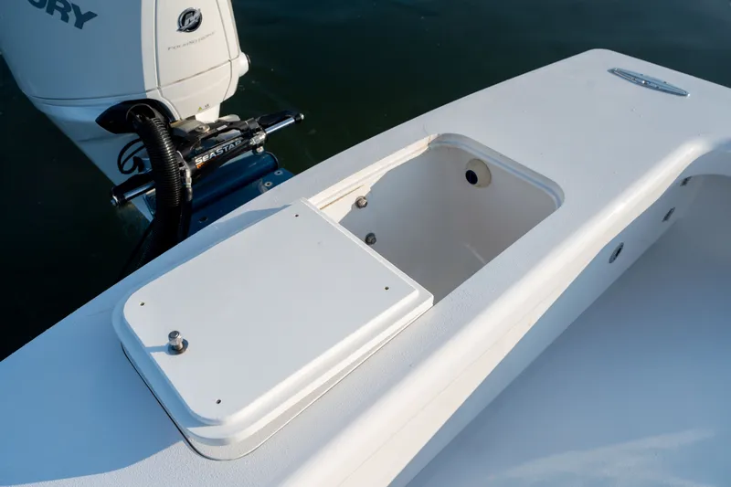 Slide: The Image of 2021 Harrison Boatworks 23 Center Console with open storage compartment and Mercury engine. - 24