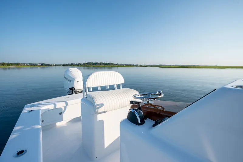 Slide: The Image of 2021 Harrison Boatworks 23 Center Console on calm water, showcasing sleek design and seating. - 19