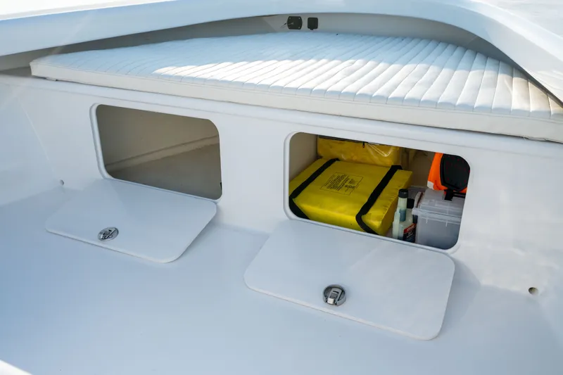 Slide: The Image of 2021 Harrison Boatworks 23 Center Console storage compartments with safety gear and supplies. - 26