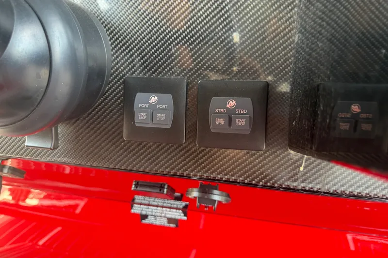 Slide: The Image of Dashboard controls of 2024 Nor-Tech 390 Sport boat with carbon fiber finish. - 16