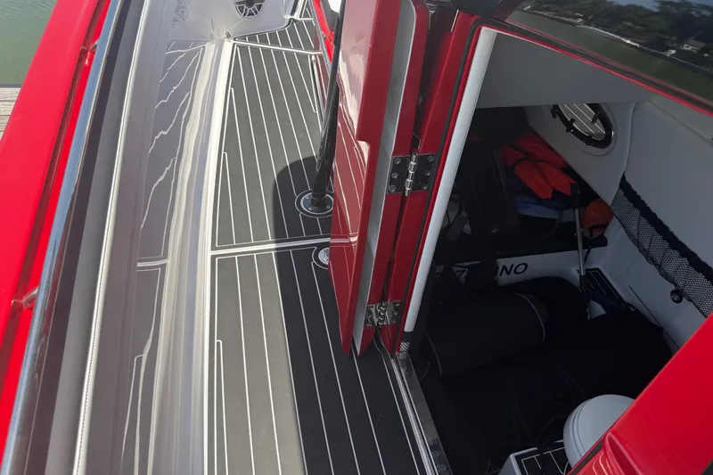 Slide: The Image of 2024 Nor-Tech 390 Sport boat interior with red accents and storage area. - 30