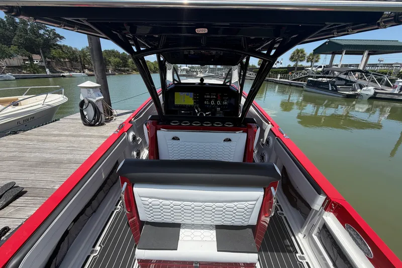 Slide: The Image of 2024 Nor-Tech 390 Sport boat interior with modern dashboard and seating at a marina. - 45