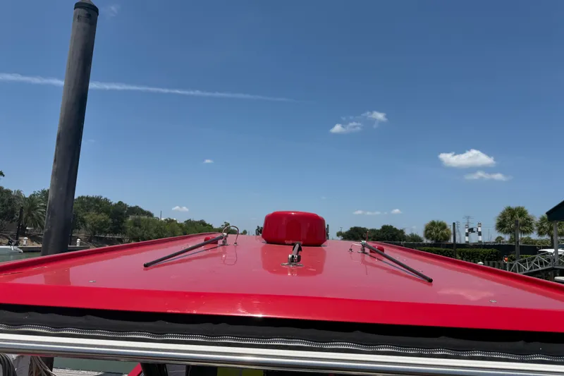 Slide: The Image of Red roof of 2024 Nor-Tech 390 Sport boat under clear blue sky. - 44