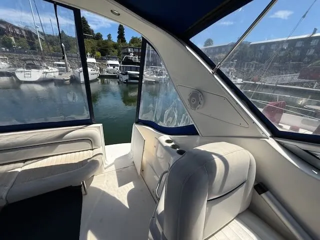 Slide: The Image of The image shows the cockpit of a 2004 Bayliner 305SB in a marina, featuring white seats and blue accents. - 10