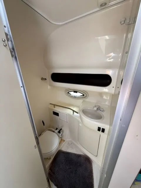 Slide: The Image of The image shows a compact boat bathroom with a toilet, sink, and small window. - 26