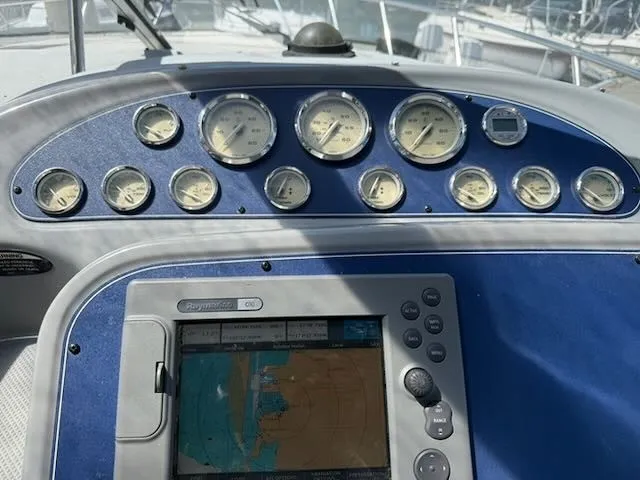 Slide: The Image of The image shows the dashboard of a 2004 Bayliner 305SB with multiple gauges and a navigation system. - 13