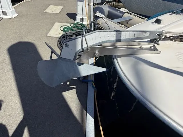 Slide: The Image of An anchor is attached to the front of a Bayliner 305SB boat, docked at a pier. - 30