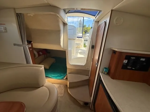 Slide: The Image of Interior of a 2004 Bayliner 305SB with seating area, bed, and stairs to the cabin. - 28