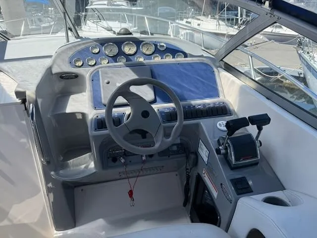 Slide: The Image of The image shows the helm of a 2004 Bayliner 305SB with multiple gauges and a steering wheel. - 18