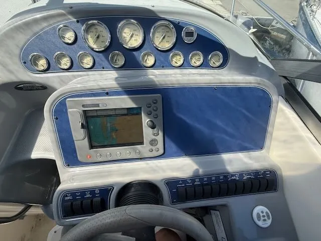 Slide: The Image of The image shows the dashboard of a 2004 Bayliner 305SB with multiple gauges and a navigation system. - 12