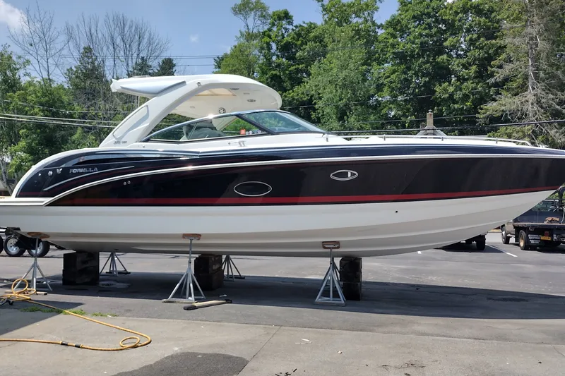 Slide: The Image of 2026 Formula 350 Crossover Bowrider on stands, sleek design, black and white exterior. - 9
