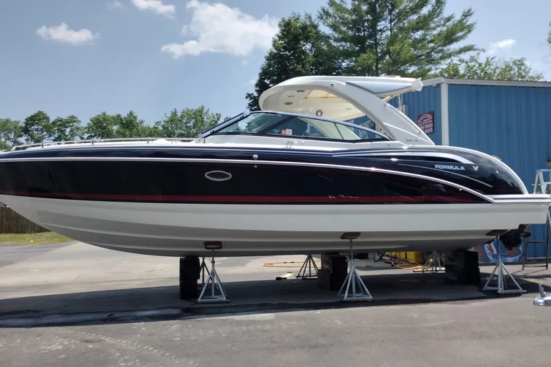 Slide: The Image of 2026 Formula 350 Crossover Bowrider boat on stands, outdoors, with blue building background. - 5