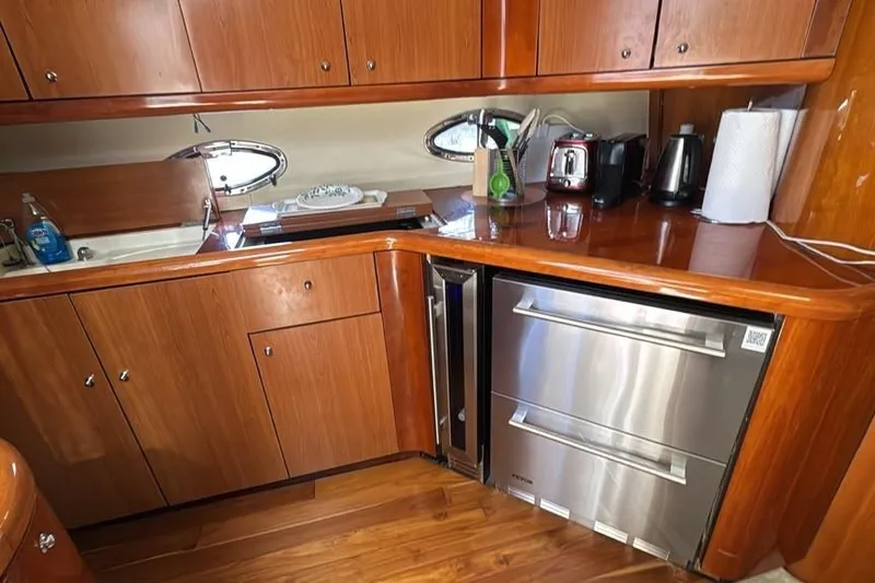 Slide: The Image of Luxurious 2003 Sunseeker Portofino 46 yacht kitchen with wooden cabinetry and modern appliances. - 19