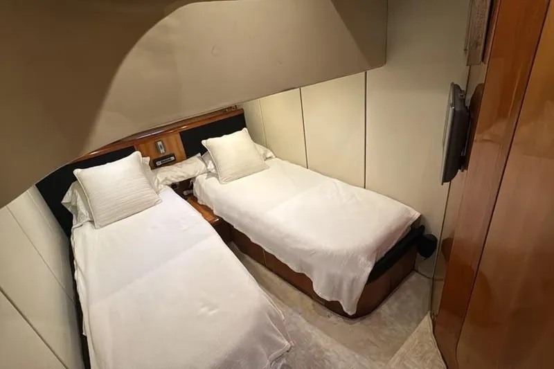 Slide: The Image of Twin beds in the 2003 Sunseeker Portofino 46 yacht cabin, featuring elegant wood paneling. - 20
