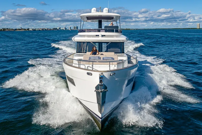 Slide: The Image of 2023 Sirena Flybridge yacht cruising on open water under a clear blue sky. - 4