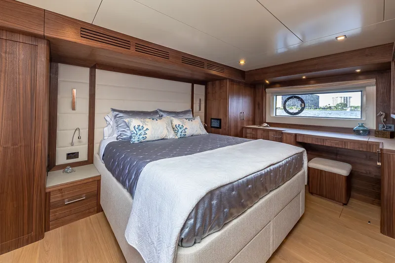 Slide: The Image of Luxurious 2023 Sirena Flybridge yacht bedroom with elegant wood finishes and scenic window view. - 44