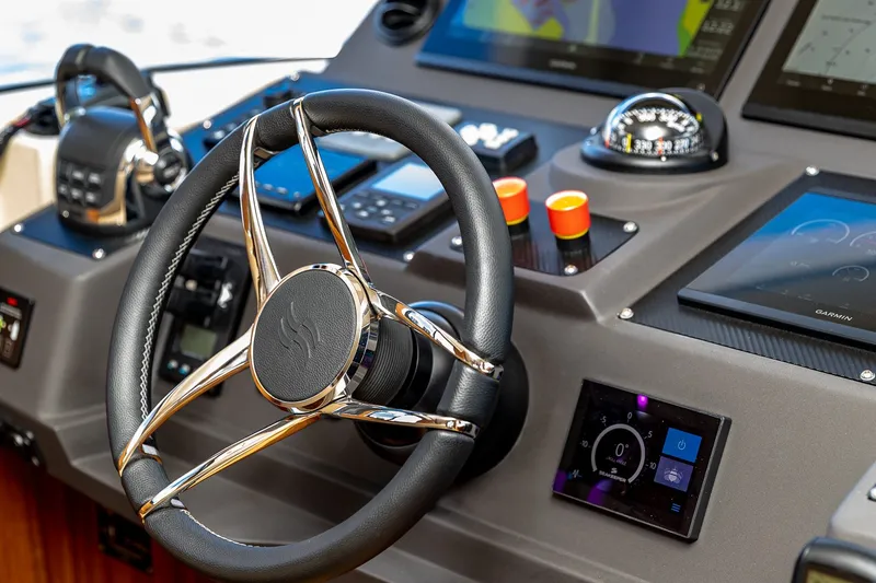 Slide: The Image of Steering wheel and dashboard of 2023 Sirena Flybridge yacht, featuring advanced navigation controls. - 38