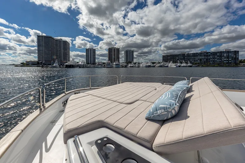 Slide: The Image of Luxurious 2023 Sirena Flybridge yacht with sunbed, overlooking waterfront cityscape. - 22