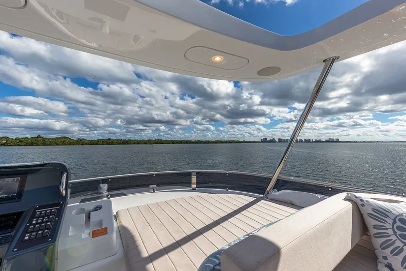 Slide: The Image of Luxurious 2023 Sirena Flybridge yacht with spacious deck, overlooking serene waters and skyline. - 30