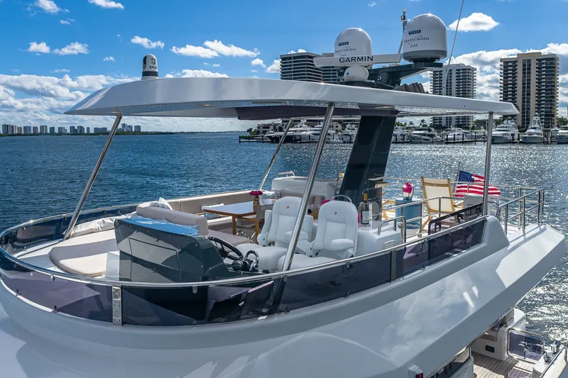 Slide: The Image of Luxurious 2023 Sirena Flybridge yacht on water, featuring elegant seating and modern navigation equipment. - 23