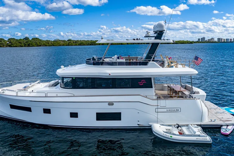 Slide: The Image of 2023 Sirena Flybridge yacht on calm water, featuring sleek design and luxury amenities. - 7