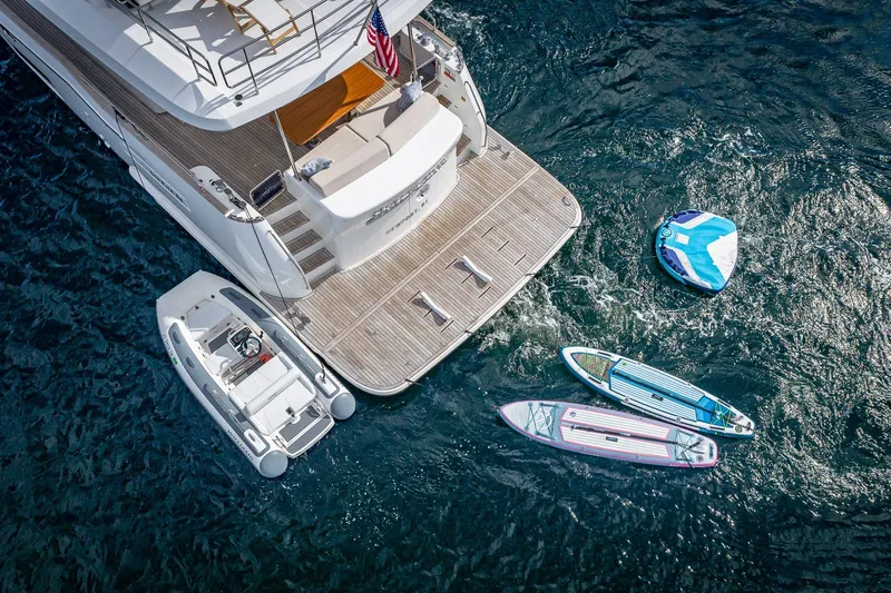 Slide: The Image of Aerial view of 2023 Sirena Flybridge yacht with paddleboards and inflatable boat on water. - 8