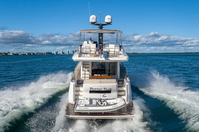 Slide: The Image of 2023 Sirena Flybridge yacht cruising on open water under a clear sky. - 5