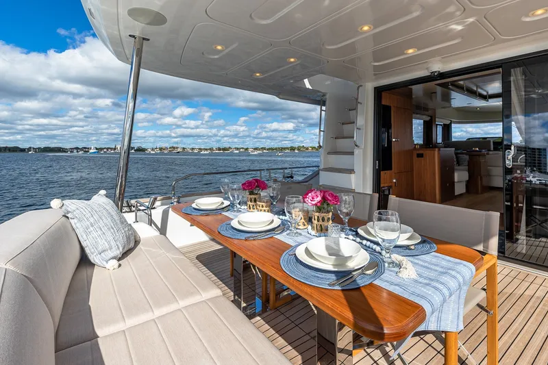 Slide: The Image of Luxurious 2023 Sirena Flybridge yacht with elegant outdoor dining setup overlooking serene waters. - 15