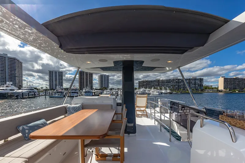 Slide: The Image of 2023 Sirena Flybridge yacht with elegant deck, marina view, and modern seating area. - 27