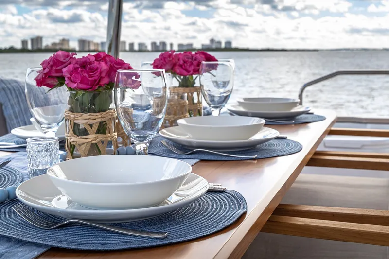 Slide: The Image of Elegant dining setup on 2023 Sirena Flybridge yacht, featuring pink roses and waterfront view. - 16
