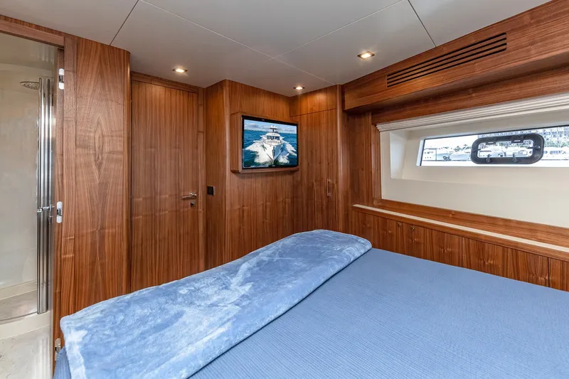 Slide: The Image of Luxurious 2023 Sirena Flybridge yacht bedroom with wood paneling and ocean view window. - 52