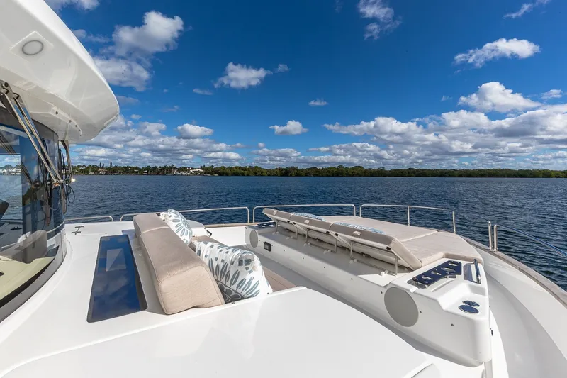 Slide: The Image of Luxurious 2023 Sirena Flybridge yacht deck with seating, overlooking serene water and blue sky. - 18