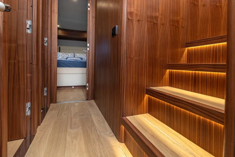 Slide: The Image of Luxurious wooden interior of 2023 Sirena Flybridge yacht with illuminated stairs and cozy bedroom. - 40